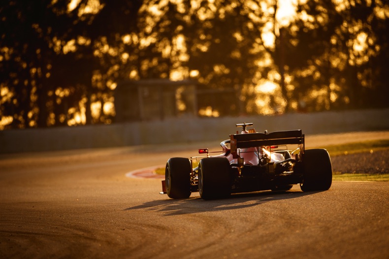 F1 car driving in the sunset