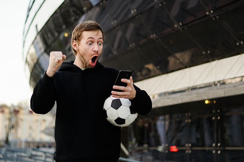 Football Player Gambling on Smartphone