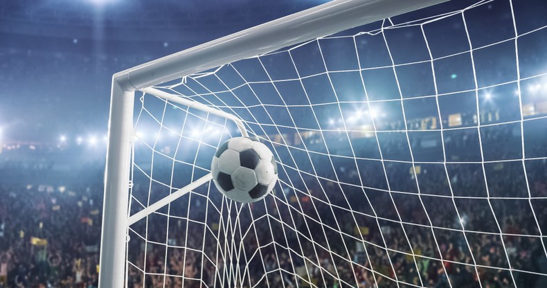 Football in Top Corner of Goal in Stadium