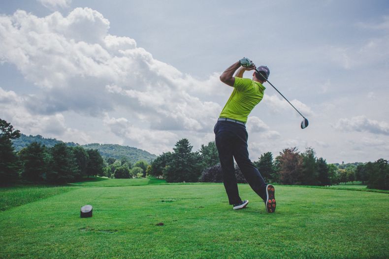 Golfer Taking Swing at Ball